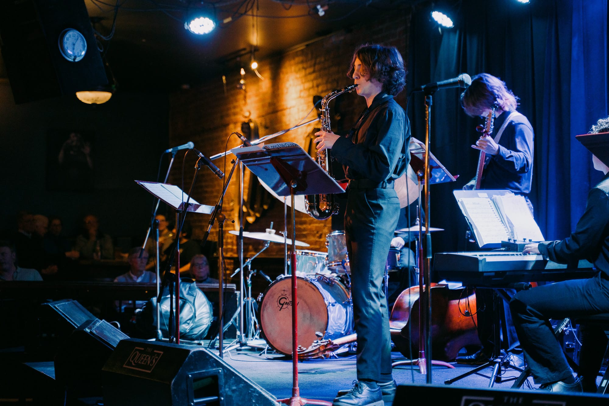 A young saxophonist performs with a student jazz band at The Queen's